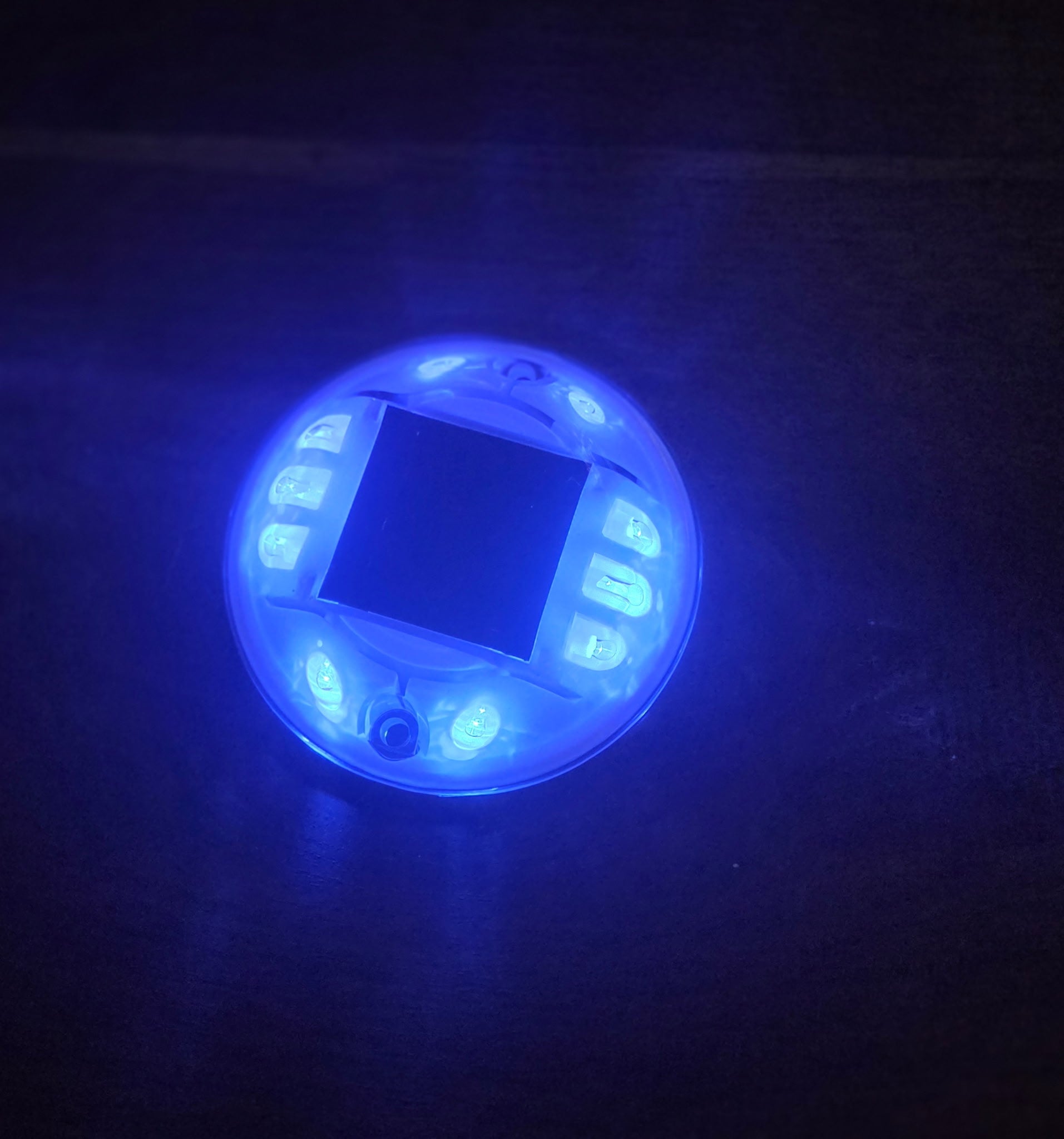 Low‑profile solar dock light marking the edge of a pier at night