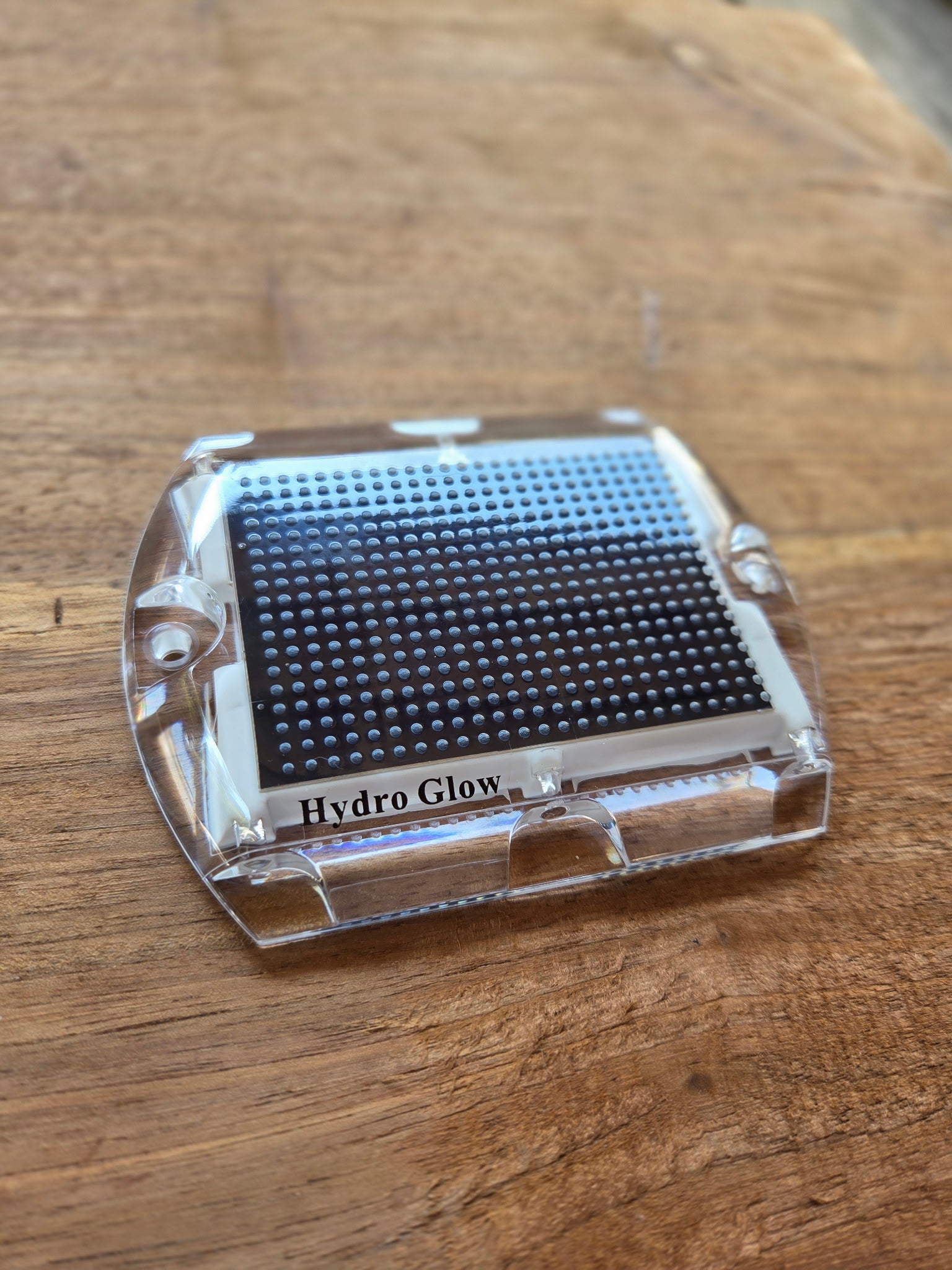 Low‑profile solar dock light marking the edge of a pier at night.