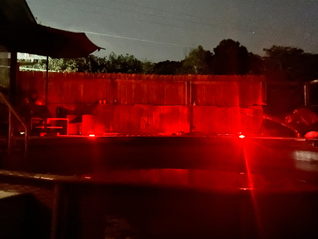 Low‑profile solar dock light marking the edge of a pier at night