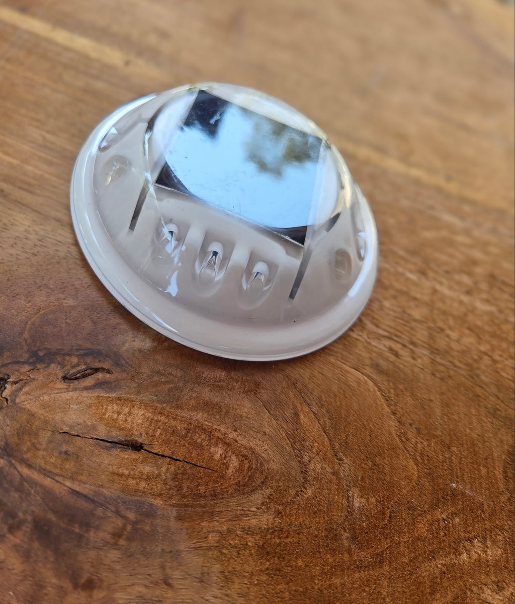 Low‑profile solar dock light marking the edge of a pier at night