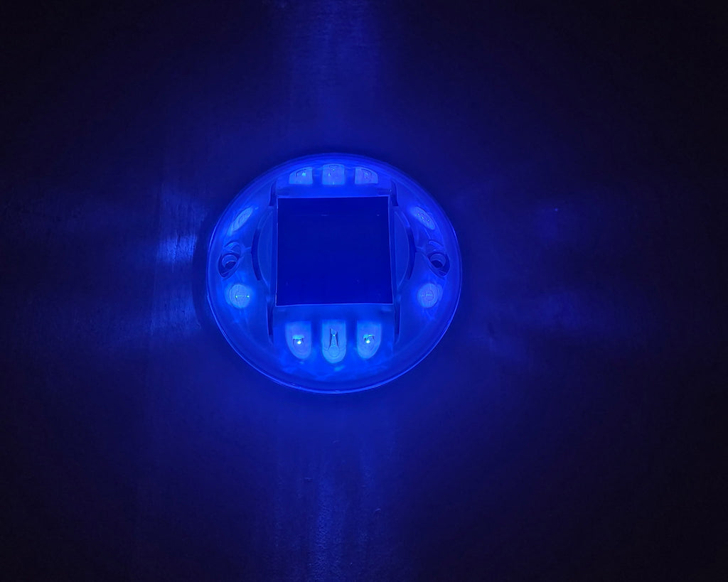 Low‑profile solar dock light marking the edge of a pier at night