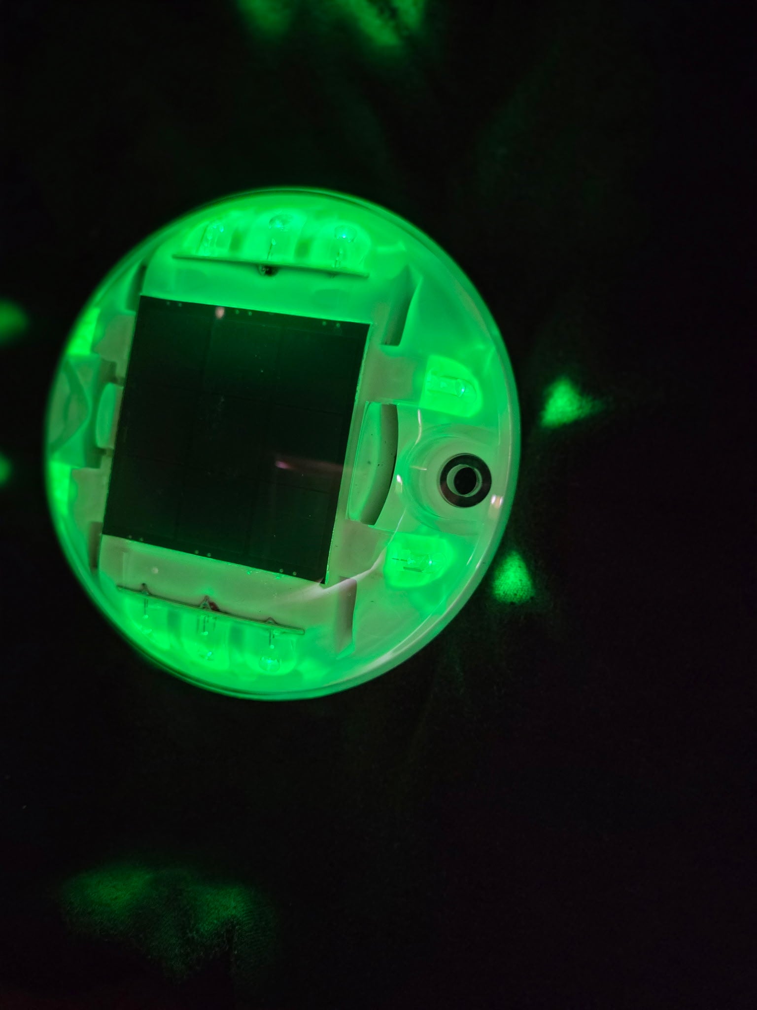Low‑profile solar dock light marking the edge of a pier at night
