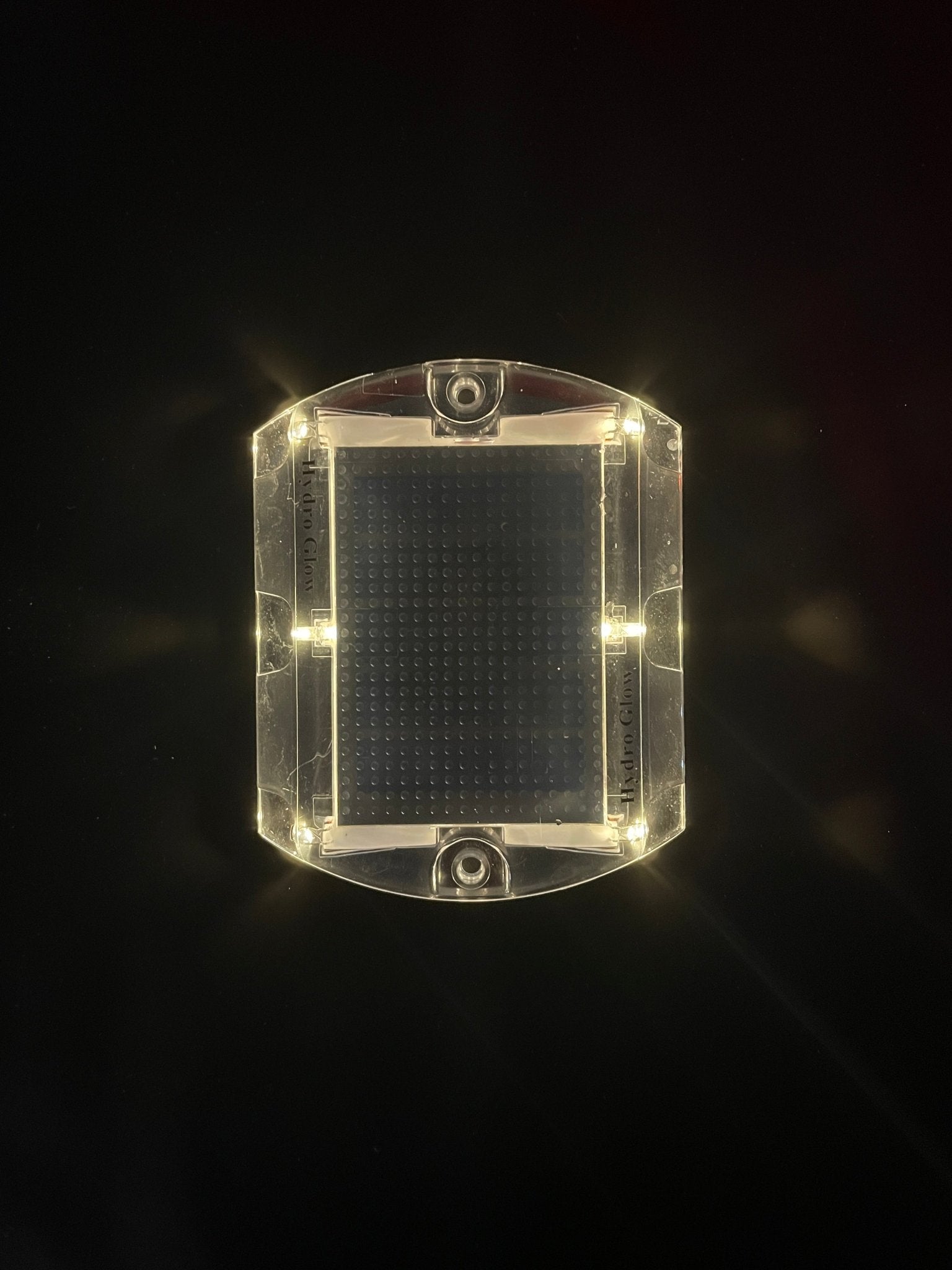 Low‑profile solar dock light marking the edge of a pier at night